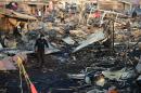 Firefighters work amid the debris left by a huge blast that occured in a fireworks market in Mexico City, on December 20, 2016 killing at least nine people and injuring 70, according to police