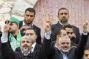 Hamas chief Khaled Meshaal and senior Hamas leader Ismail Haniyeh flash victory signs upon arrival at a rally marking the 25th anniversary of the founding of Hamas, in Gaza City