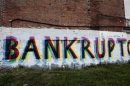 The word 'Bankruptcy' is seen painted on the side of a vacant building by street artists as a statement on the financial affairs of the city on Grand River Avenue in Detroit