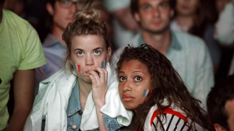 French soccer fans watch a live broadcast of the group E World Cup soccer match between Ecuador and France, in central Paris, France, Wednesday, June 25, 2014