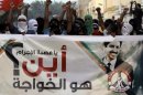 Bahraini anti-government protesters wave national flags and chant in support of jailed opposition rights activist Abdulhadi al-Khawaja on Saturday, April 28, 2012, in Abu Saiba, Bahrain. Al-Khawaja, pictured on the banner reading 