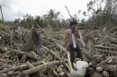 Residents search for their missing relatives among debris swept by floodwaters at the height of Typhoon Bopha, in New Bataan town