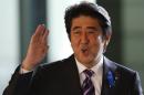 Japan's PM Abe waves upon his arrival at his official residence in Tokyo