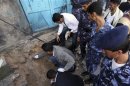 Policemen inspect the site of a roadside bomb in Sanaa