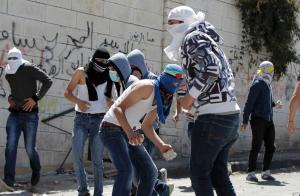 Palestinian youth prepare to throw stones at Israeli &hellip;