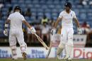 England's captain Alistair Cook, right, and teammate Jonathan Trott touch bats to celebrate runs during their partnership on day two of their second Test match against West Indies at the National Stadium in St. George's, Grenada, Wednesday, April 22, 2015. (AP Photo/Ricardo Mazalan)