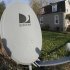 This photo made with a fisheye lens on Nov. 2, 2011, shows a DirecTv satellite dish on a post in the front yard of a home in Harmony, Pa. Satellite TV provider DirecTV said Thursday, Nov. 3, 2011, it raked in more subscribers than ever in the third quarter, helped by the NFL Sunday Ticket. (AP Photo/Keith Srakocic)