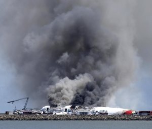 Fire crews work the crash site of Asiana Flight 214 …