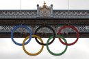 The Olympic rings are seen atop the iconic Tower Bridge in London, after they were lowered into position, coinciding with one month to go until the start of London 2012 Games, Wednesday, June 27, 2012. The giant rings, which are fully retractable to allow for tall ships to pass through the bridge, will remain in position for the duration of the Games. (AP Photo/Lefteris Pitarakis)
