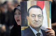 A supporter of Egypt's ousted President Hosni Mubarak, pictured, rally outside a courtroom in Cairo, Saturday, May 11, 2013. Egyptian prosecutors say they are presenting new evidence in the retrial of Mubarak. The former president, all in white and wearing sunglasses, attended the hearing in the courtroom defendants' cage alongside his two sons and former interior minister, who was in charge of police at the time. (AP Photo/Khalil Hamra)