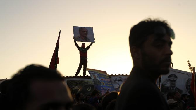 A Libyan protestor carries a placard depicting general Khalifa Haftar during a demonstration in support of the army and against the UN-backed unity government in Benghazi this month