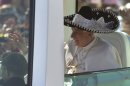 Pope Benedict XVI waves from the popemobile wearing a Mexican sombrero as he arrives to give a Mass in Bicentennial Park near Silao, Mexico, Sunday, March 25, 2012. (AP Photo/Eduardo Verdugo)