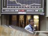 A trader walks under a chart at a bourse in Madrid
