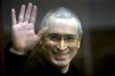 Mikhail Khodorkovsky waving from the defendant's cage in a Moscow courtroom, on November 2, 2010