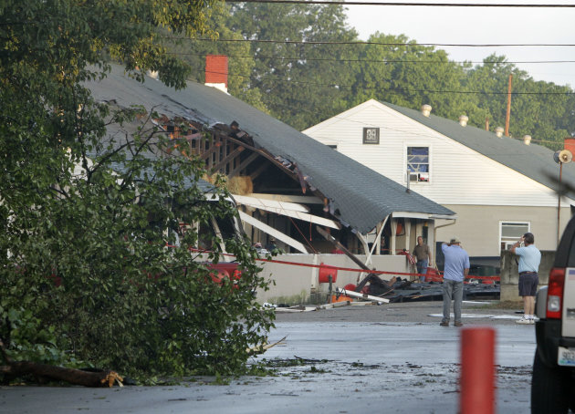 People survey the damage Thursday, June 23, 2011, near the barn used by trainer Ian Wilkes at Churchill Downs after a possible tornado hit the race track Wednesday night in Louisville, Ky. The Nationa