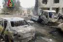 In this image made from video obtained from the Shaam News Network, which has been authenticated based on its contents and other AP reporting, vehicles smolder after an explosion outside a mosque in Yadouda, Syria, Friday, Feb. 14, 2014. A car bomb blew up outside a mosque in a rebel-held village in southern Syria as worshippers were leaving after Friday prayers, killing dozens of people and filling clinics and hospitals with the wounded, anti-government activists said. (AP Photo/Shaam News Network)