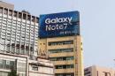 Workers take a billboard of Samsung Electronics' Galaxy Note 7 off from atop a building in central Seoul