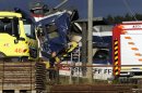 A rescue worker stands near two Swiss regional trains after a head-on collision near Granges-Pres-Marnand near Payerne