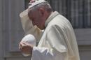 Pope Francis exchanges his skull cap with one donated to him as he leaves at the end of his weekly general audience in St. Peter's Square at the Vatican, Wednesday, June 10, 2015. (AP Photo/Alessandra Tarantino)