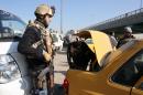 Iraqi security forces search the boot of a car at a checkpoint in Baghdad on December 16, 2013