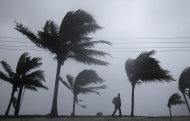 A man walks along a seaside park as Hurricane Irene passes to the east of Nassau on New Providence Island in the Bahamas, Thursday Aug. 25, 2011. Irene is pounding the Bahamas as a Category 3 hurricane. (AP Photo/Lynne Sladky)