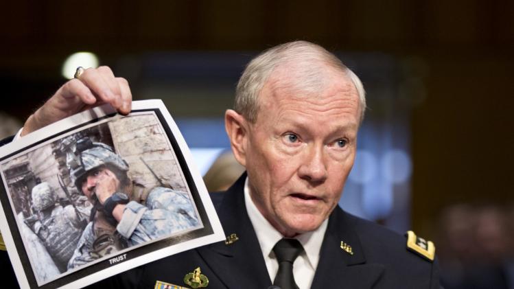 FILE - In this July 18, 2013, file photo, Gen. Martin Dempsey, chairman of the Joint Chiefs of Staff, holds up a photo of a deployed American soldier as he testifies before the Senate Armed Services Committee at his reappointment hearing, on Capitol Hill in Washington. The Obama administration is opposed to even limited U.S. military intervention in Syria because it believes rebels fighting the Assad regime wouldn’t support American interests if they were to seize power right now, Dempsey said in a letter to a congressman obtained by The Associated Press. (AP Photo/J. Scott Applewhite, File)