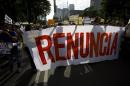 Protestors carry a banner reading in Spanish: "Resign" during a march calling for the resignation of Mexico's President Enrique Pena Nieto in Mexico City, Thursday, Sept. 15, 2016. Mexico will mark the 206th anniversary of its independence from Spain on Friday with a massive military parade presided over by the president. (AP Photo/Rebecca Blackwell)