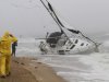 A stranded sailboat founders in the surf along the Willoughby Spit area of Norfolk, Va. as Hurricane Irene hits Norfolk, Va., Saturday, Aug. 27, 2011. The live-aboard couple attempted to outrun the storm and got caught up in the high surf and wind. They were rescued by local fire and rescue personnel.  (AP Photo/Steve Helber)