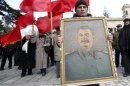 People carry red flags and a portrait of the late Soviet leader Josef Stalin during a ceremony to mark the 60th anniversary of his death in his hometown of Gori