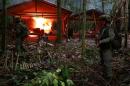 A Colombian anti-narcotics policeman stands guard after burning a cocaine lab, which police said belongs to criminal gangs, in a rural area of Calamar in Guaviare state, Colombia