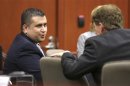 George Zimmerman talks with defense counsel Mark O'Mara at the Seminole County courthouse after a hearing in Sanford
