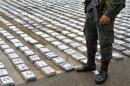 A Colombian police officer stands guard next to packages of cocaine in Turbo, department of Antioquia in Colombia, on May 18, 2014