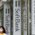 A woman walks past logos of Softbank Corp at its branch in Tokyo