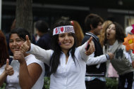 A fan of Canadian pop star Justin Bieber wearing a headband with an "I love Justin Bieber" message, flashes two thumbs up, outside the hotel in which Bieber is staying in Mexico City, Tuesday, Nov. 19, 2013. Mexico's president has denied a tweet by Bieber saying the singer met with the president and his family prior to Monday's night show. It was the latest sour note in Bieber's controversy-filled Latin American tour. (AP Photo/Marco Ugarte)