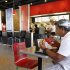 In this March 28, 2012 photo, Norman Garcia eats a burger and fries at a Burger King restaurant in Miami. Burger King launches 10 menu items including smoothies, frappes, specialty salads and snack wraps in a star-studded TV ad campaign. It's the biggest menu expansion since the chain opened its doors in 1954. (AP Photo/Luis M. Alvarez)