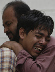 People mourn the death of their family member by shooting in Karachi, Pakistan on Thursday, Aug 18, 2011. A wave of violence killed 33 people in the last 24 hours in Pakistan's largest city, with many of the victims tortured, shot and stuffed in sacks that were dumped on the streets, officials said Thursday. (AP Photo/Fareed Khan)