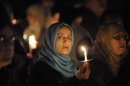Mourners hold up candles at a candle light vigil held at a city park in Santee, California, for Shaima Alawadi