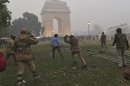 Policeman uses a baton to disperse a demonstrator during a protest in front of India Gate in New Delhi