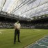 An official stands on the grass as the roof is closed over Centre Court at the Wimbledon tennis championships in London
