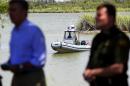 A U.S. Border Patrol boat secures the area as U.S. Customs and Border Protection Commissioner Gil Kerlikowske, left, talks about the dangers of crossing the U.S. border during a news conference for a Danger Awareness Campaign at Anzalduas Park next to the Rio Grande River in Mission, Texas on Wednesday July 2, 2014. The campaign is a Spanish-language outreach effort aimed at highlighting the risks and undercutting the perceived rewards of illegal immigration. (AP Photo/The Monitor, Gabe Hernandez)