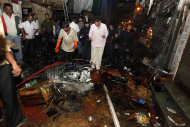 Policemen inspect the site of a bomb explosion at Zaveri bazaar in Mumbai, India, Wednesday, July 13, 2011. Three explosions rocked India's busy financial capital at rush-hour Wednesday, killing at least eight people and injuring 70 in what officials described as another terror strike on the city hit by militants nearly three years ago. (AP Photo)