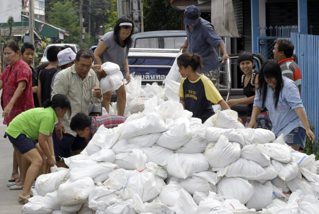 Villagers unload sand bags for flooding barriers in Pak Kred district, Nonthaburi province, Thailand Thursday, Oct. 13, 2011. The ongoing floods is the worst to hit the Southeast Asian nation in decad