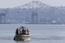 Rescue workers on a boat search the Hudson River south of the Tappan Zee Bridge for two people who are believed to have fallen into the water during a boat crash in Piermont, N.Y. on Saturday, July 27, 2013. Two people are missing and four others are injured after their boat struck a barge under the bridge, according to the Coast Guard. (AP Photo/Julio Cortez)