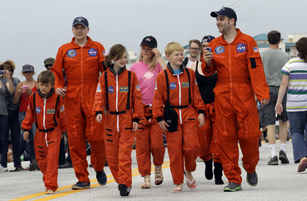 The Howard family from Huddersfield, England, walk along the Max Brewer Bridge before space shuttle Atlantis lifts off Friday, July 8, 2011, in Titusville, Fla. Four astronauts are taking space shuttl