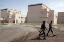 Iraqi police walk past the Basra Children's Hospital on August 12, 2010. Today, it still isn't finished.