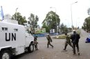 Congolese Revolution Army rebels walk past a U.N. patrol truck parked along a street in Goma, soon after capturing the city from the government army
