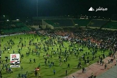 In this still image taken from video, soccer fans invade the pitch during a soccer match between Al Ahli and al-Masry in Port Said