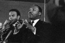FILE - In this Feb. 7, 1968 file photo, Dr. Martin Luther King Jr., center, speaks to an audience, while promising a massive demonstration in the spring in Washington and hinting the crusade may be extended to the political party conventions in August. King, president of the Southern Christian Leadership Conference said the demonstration in Washington will last for weeks and maybe for months. At left is the Rev. Andrew Young, executive Vice President of the Southern Conference. Veterans of past social movements, such as Young, say the Occupy Wall Street protest has been a welcome response to the abysmal economy and has the potential to galvanize wide support, but whether it will lead to lasting political change remains to be seen. 