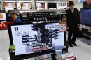 A man watches televisions reporting on North Korea's launch of a rocket at an electronic shop in Tokyo