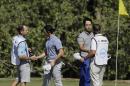 Rory McIlroy of Northern Ireland, second from left, and Kevin Na, second from right, and their caddies exchange hand shakes following a sudden-death playoff during round-robin play at the Dell Match Play Championship golf tournament at Austin County Club, Friday, March 25, 2016, in Austin, Texas. McIlroy won the match. (AP Photo/Eric Gay)